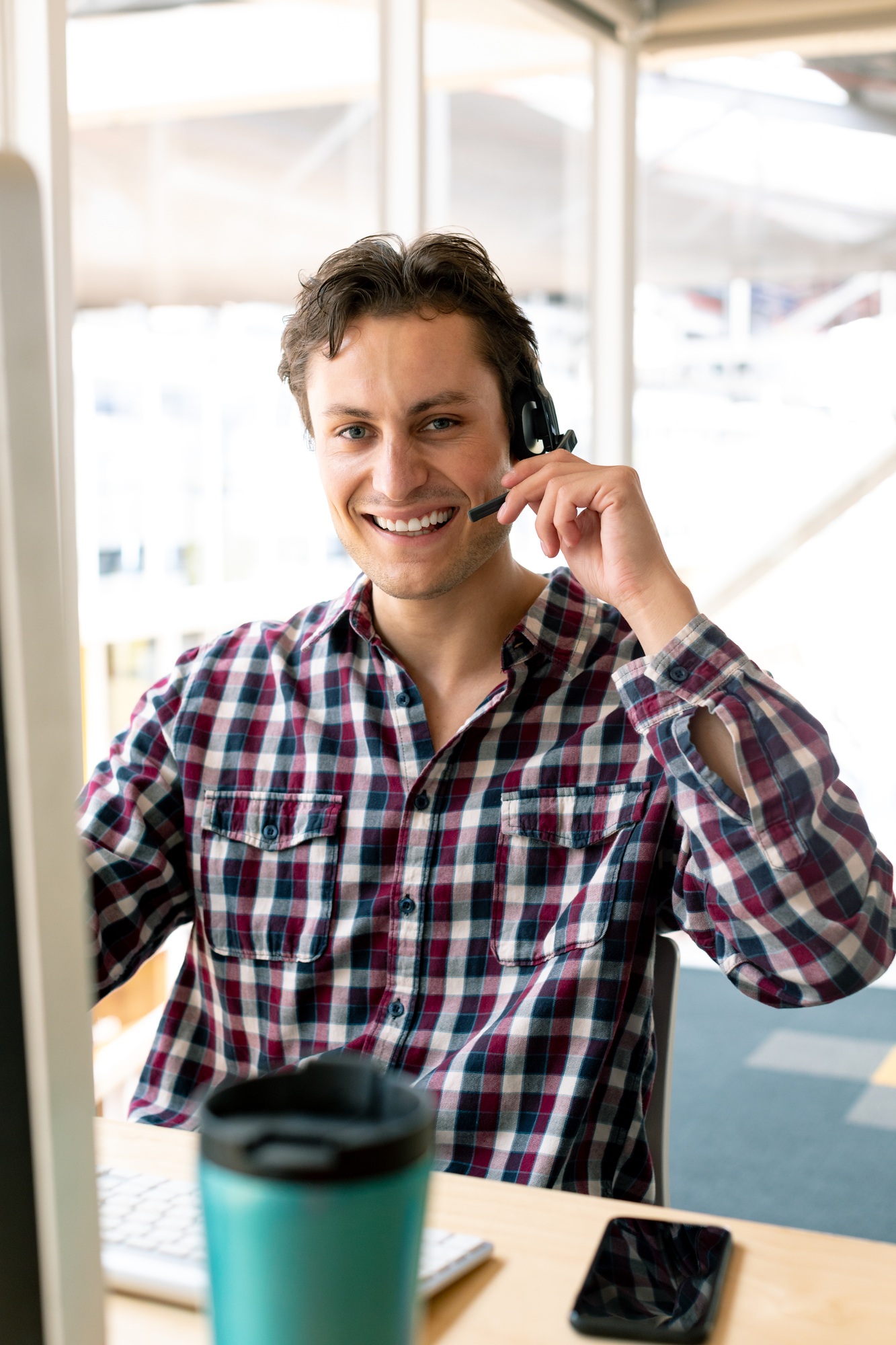 Front view of Caucasian male customer service executive talking on headset at desk in office